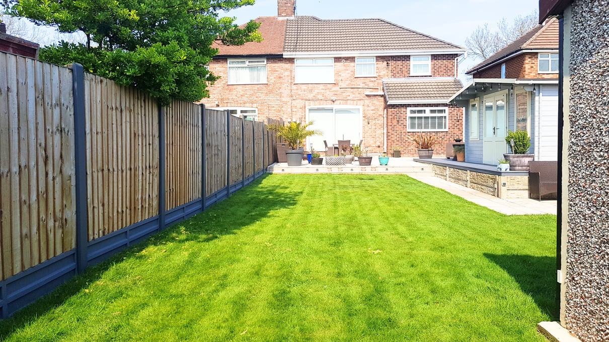 a garden with seamline eco-post covers and wooden fence